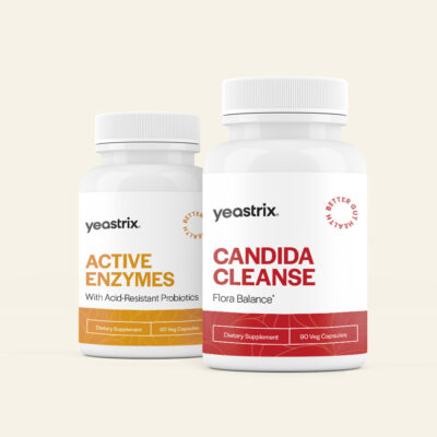 Two bottles of dietary supplements. The left bottle is labeled "Active Enzymes" and the right bottle is labeled "Candida Cleanse." Both have "yeastrix" branding.