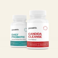 Two white bottles of Yeastrix supplements: Daily Probiotic on the left and Candida Cleanse on the right, placed against a light background.