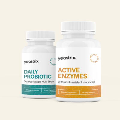 Two bottles of Yeastrix supplements on a light background. One labeled "Daily Probiotic," the other "Active Enzymes." Both have 60 vegan capsules.