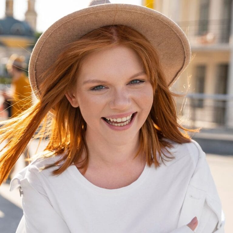a beautiful young red head girl smiling because she discovered how to get rid of recurring yeast infections for good