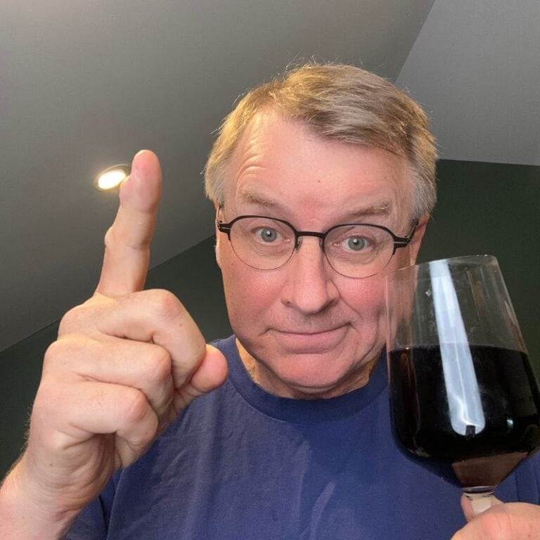 eric bakker pointing the finger and asking if does alcohol make candida worse? while holding a glass of red wine