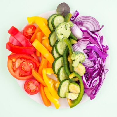 display of cut tomato, capsicum, zucchini, and red onion