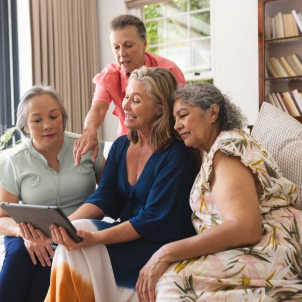 A group of women aged 40-plus gathered around a computer, discussing health and wellness considerations relevant to circulation and digestive function.