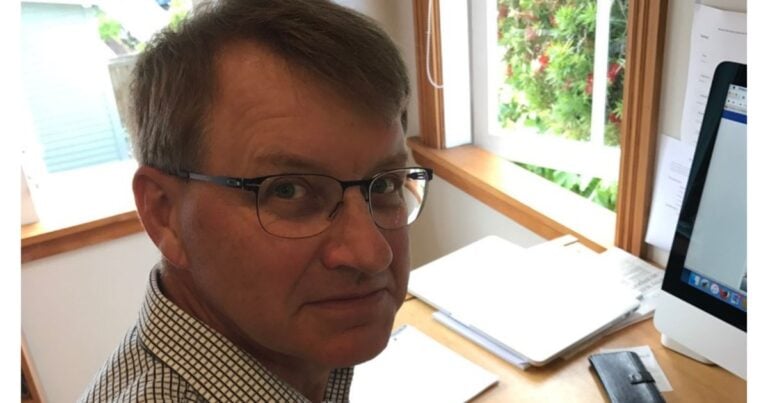 Eric Bakker, naturopath, sitting at desk by window ready to give gut health tips.