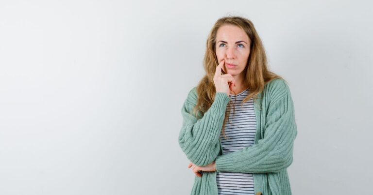 Young woman looking thoughtful, touching her cheek as if considering symptoms or health concerns, representing curiosity about vaginitis and vaginal health