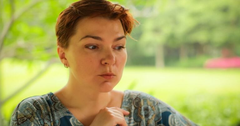 Young woman looking thoughtful with a gentle, contemplative expression, representing curiosity about whether Candida can cause vaginitis and recurring vaginal symptoms.