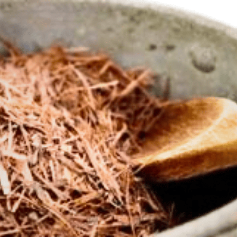 pau d'arco bark grated in a cream bowl with a wooden spoon