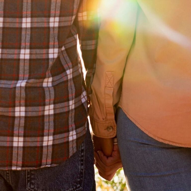 a couple holding hands viewed from behind - candida reinfection between partners