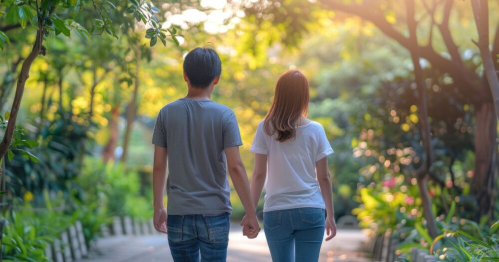 a man and woman holding hands walking in nature discussing candida reinfection between partners