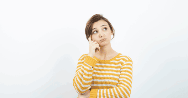 young woman looking upward and hand up to side of head with questioning expression, wondering 'can candida be cured'