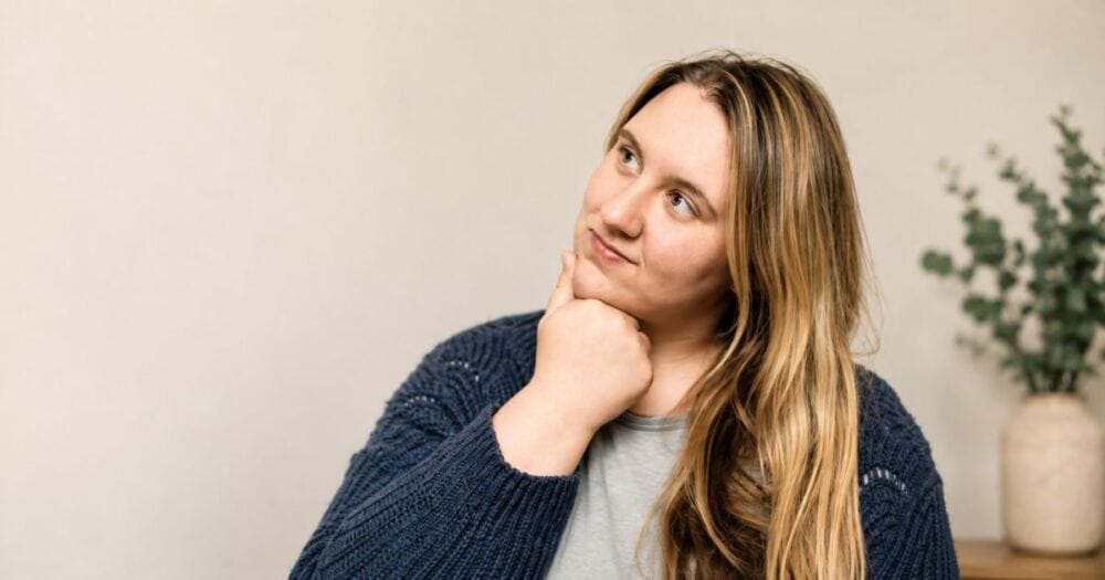 A woman sitting thoughtfully in a calm home setting, representing the connection between hormones, gut health, and Candida. Featured image for the Yeastrix article “Hormones and Candida: The Hidden Connection.”